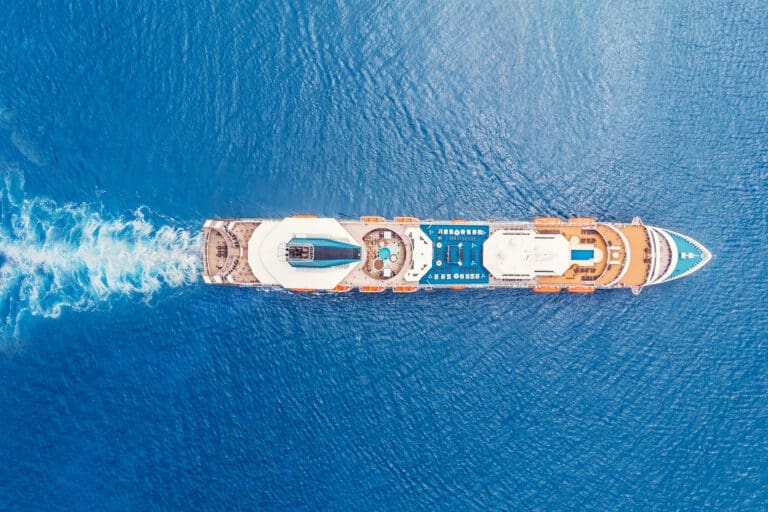 Cruise liner ship in ocean with blue water. Aerial top view