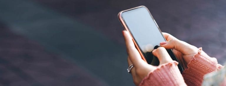 Woman hand holding a smart phone outdoors