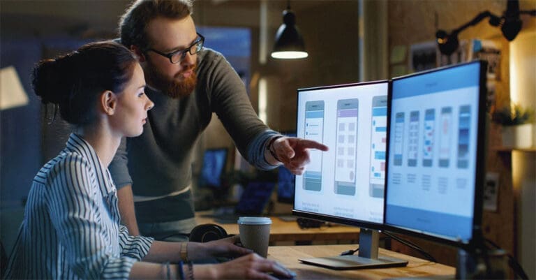 man and woman sit at a computer