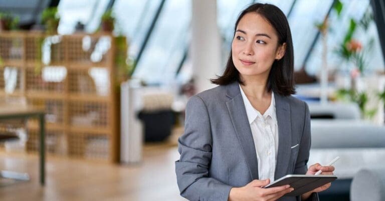 Business leader in office holding digital tablet