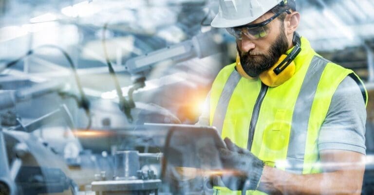 Industrial engineer holding tablet, working in manufacturing factory