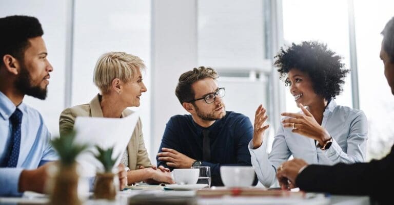 Team meeting in office, leader discussing ideas with employees