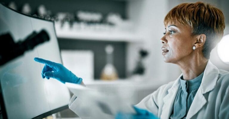 Scientist or doctor looking at computer screen, conducting medical data analysis