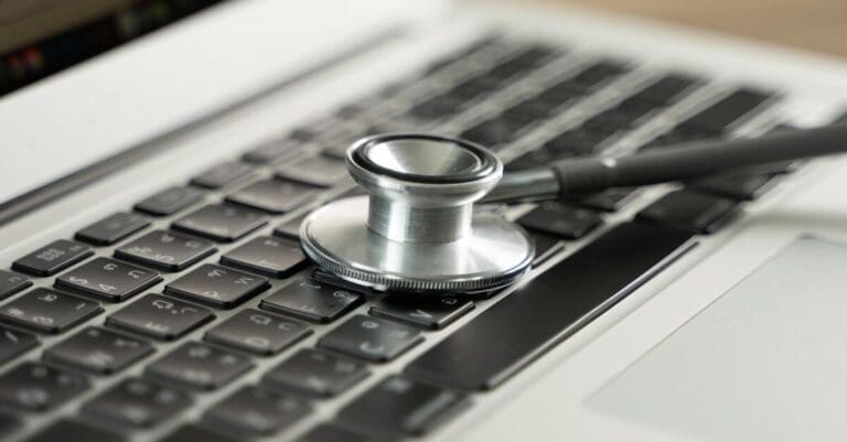 Medical stethoscope lying on computer keyboard