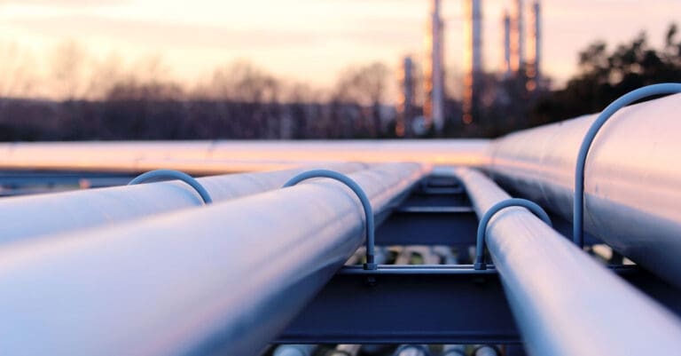 Steel long pipes in crude oil factory during sunset