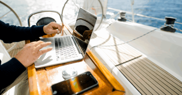 person using a laptop on a sailboat